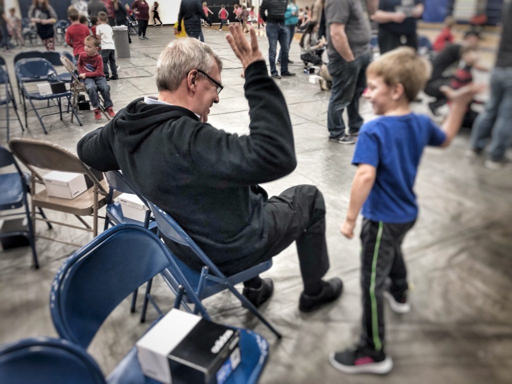 Volunteer giving a high five to a young student