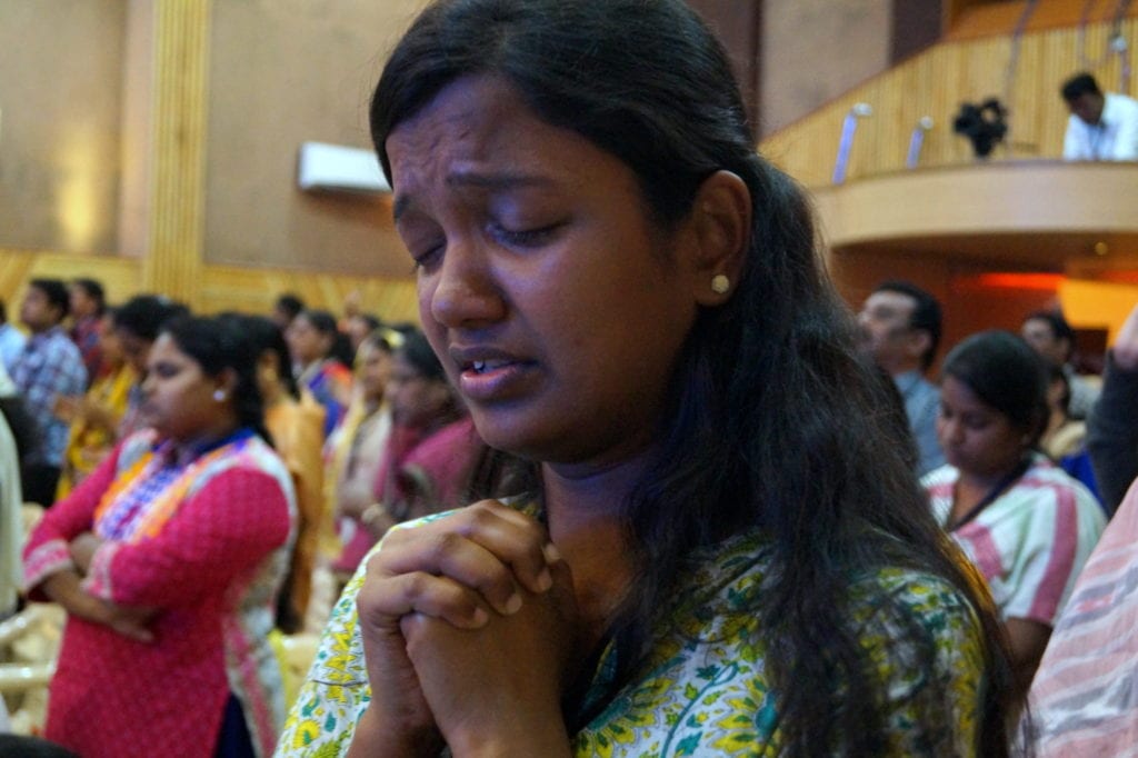 Woman praying at GLS in India