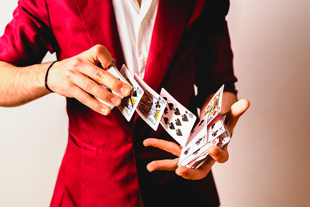 Hands of magician doing tricks with a deck of cards.
