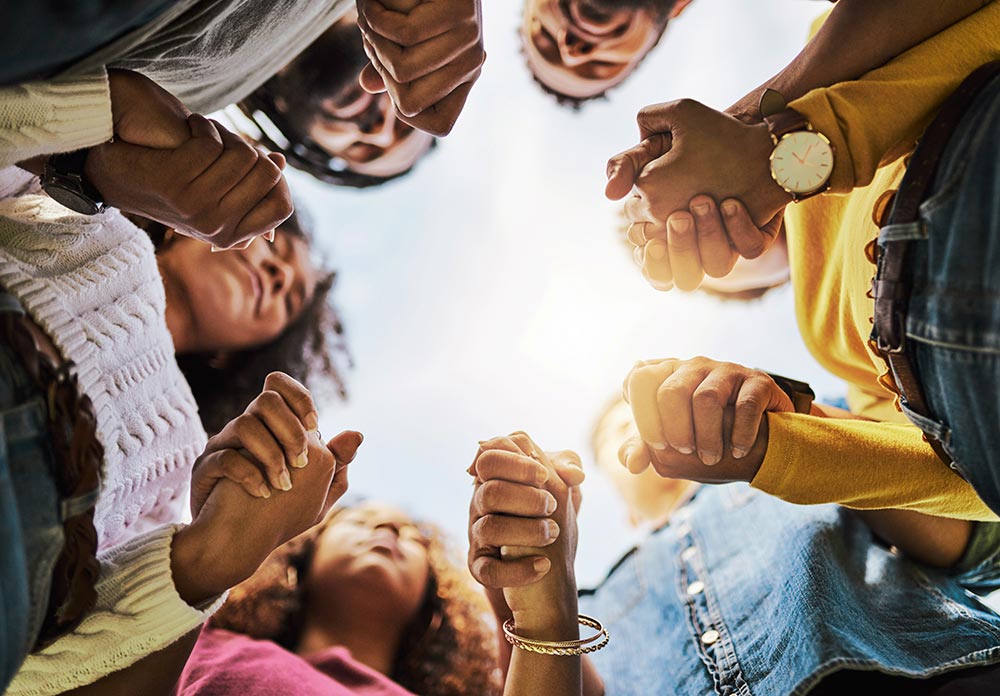 Cropped shot of a group of friends holding hands