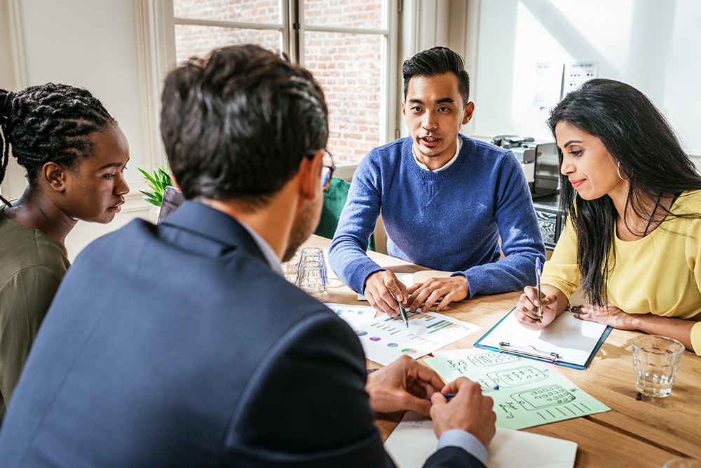 Investors sit around a conference table figuring out their next steps in partnerships.